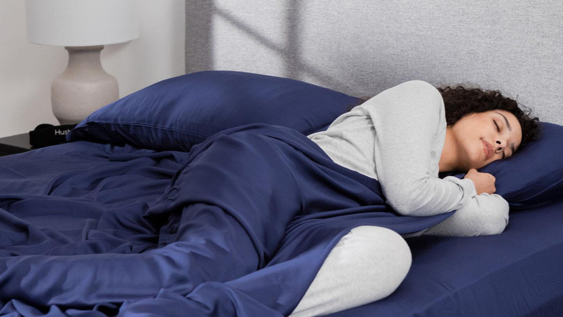 Woman sleeping on her side with Hush Bamboo Cooling Sheets in navy blue color.