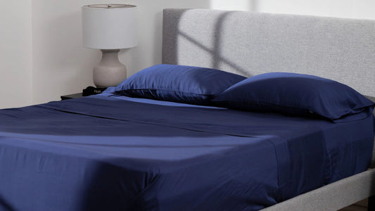 Mattress with navy blue Hush Iced sheets and pillows.