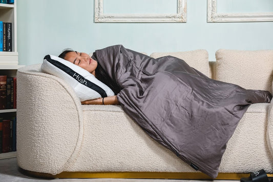 how to use a weighted blanket: woman sleeping on her couch with a blanket on