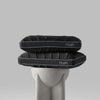 A black memory foam pillow with a blue accent on a textured grey base, labeled with the brand name 'HUSH'.