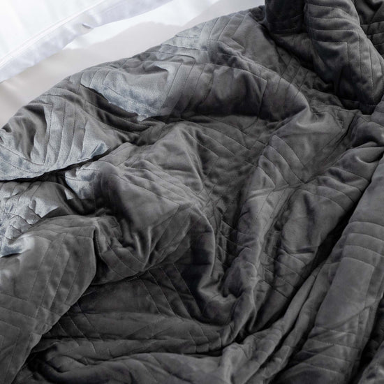 Charcoal weighted blanket cover scrunched on bed