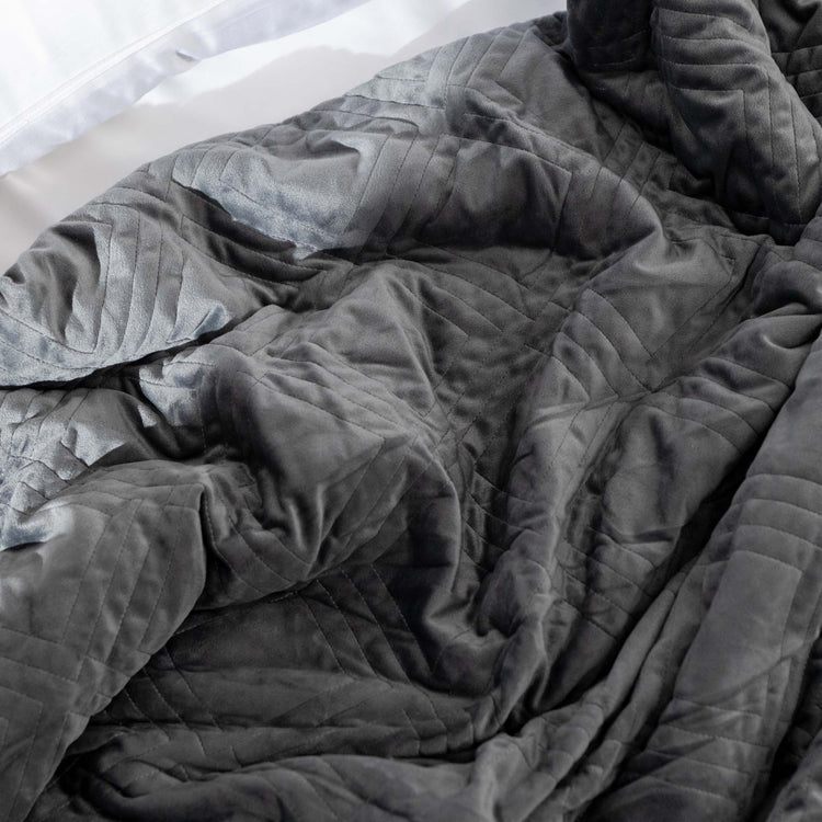 Charcoal weighted blanket cover scrunched on bed