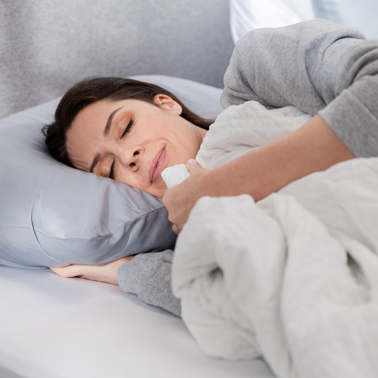 Woman sleeping under white weighted blanket