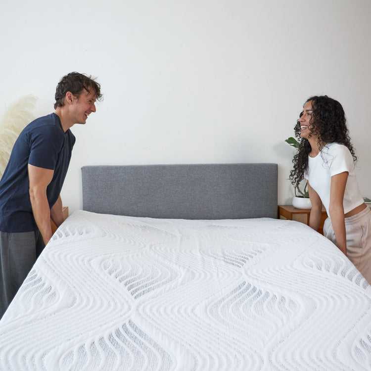 Couple placing Hush Iced Hybrid Mattress on bed frame